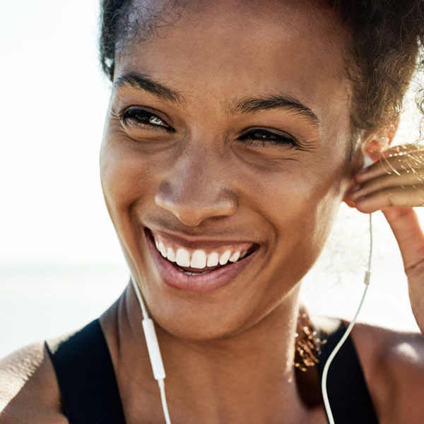 close up of woman smiling while listening to music