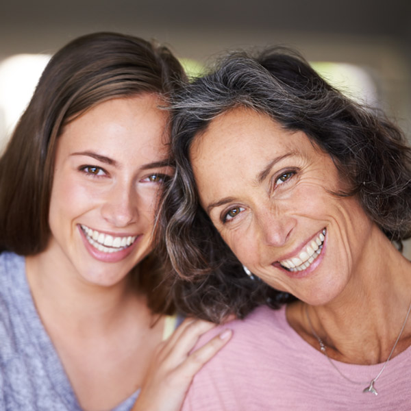 mom and adult daughter smiling together